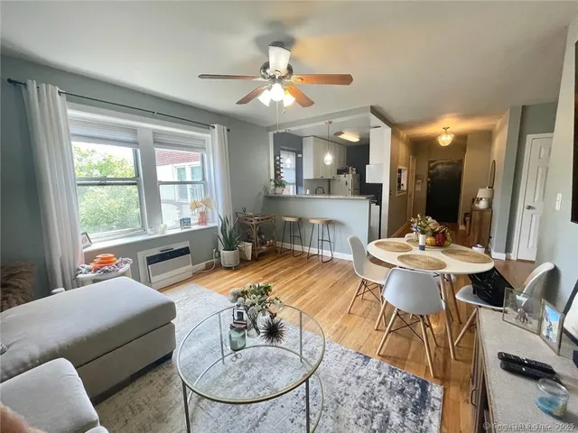 a living room with furniture a large window and dining table