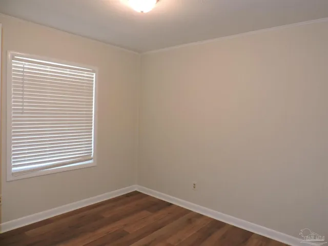 a view of a small space with wooden floor and a window