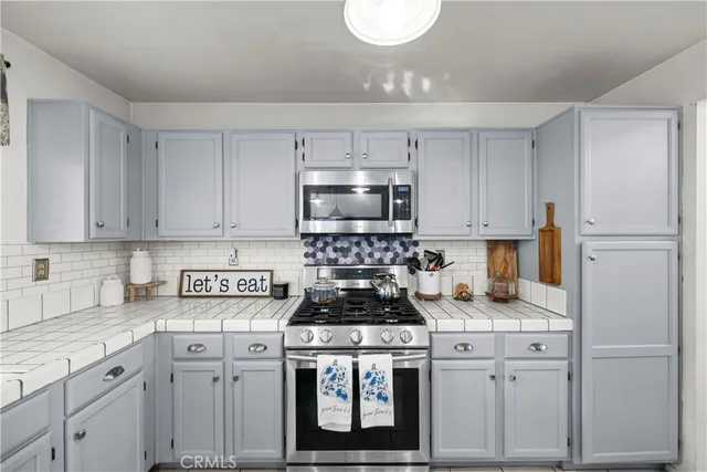 a kitchen with granite countertop white cabinets and stainless steel appliances