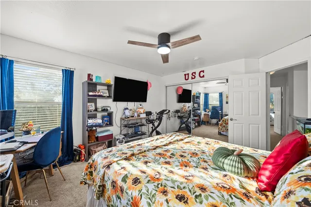 a bed room with a bed a television and a chair