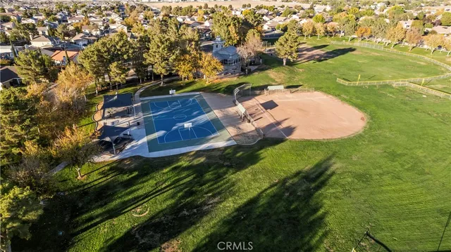 an aerial view of residential houses with outdoor space and trees
