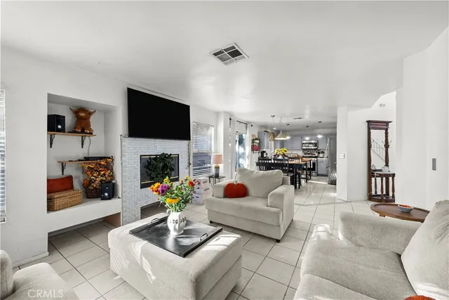 a living room with furniture a fireplace and a flat screen tv