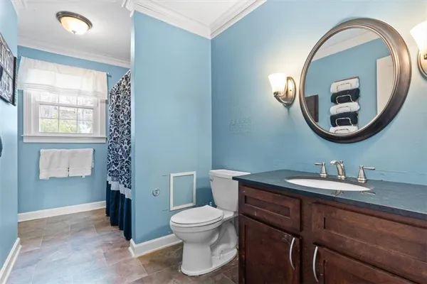 a bathroom with a toilet sink and mirror
