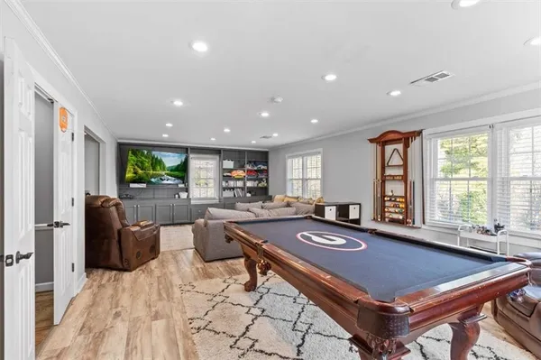 a room with furniture pool table and windows