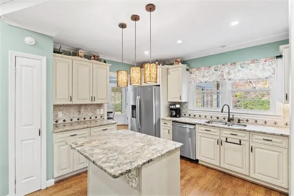 a kitchen with stainless steel appliances granite countertop a sink stove and refrigerator