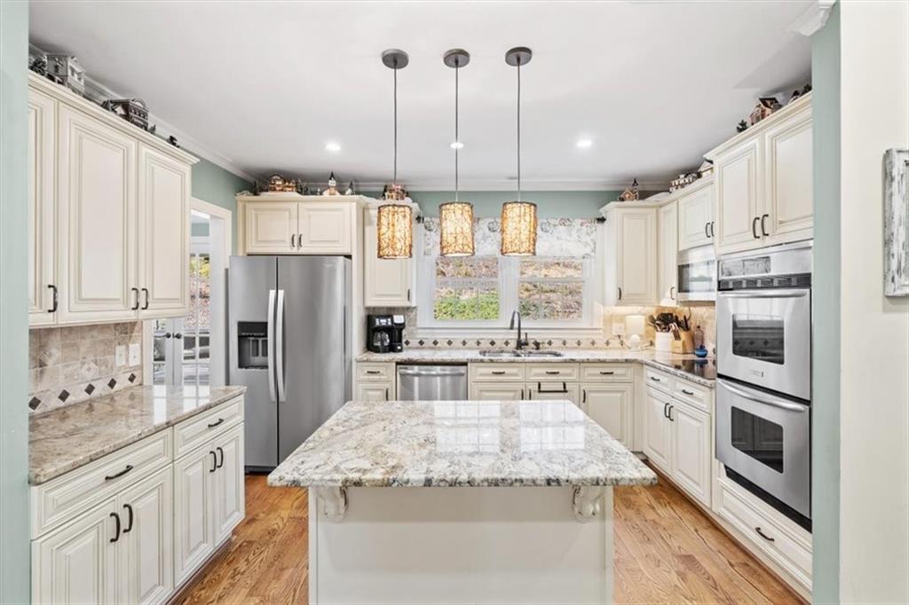 20 Pine Valley Road Rome, GA 30165 - Photo 10 of 36 a kitchen with stainless steel appliances granite countertop a refrigerator a stove a sink and white cabinets with wooden floor