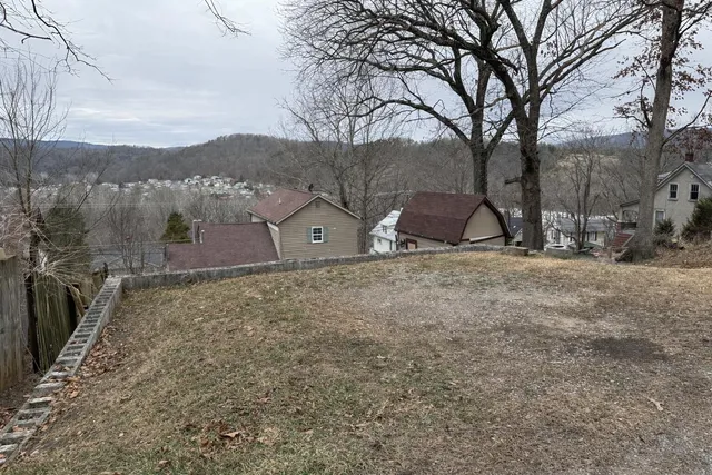 a view of a barn with a yard and large tree