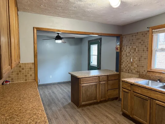 a room with a sink cabinets and wooden floor