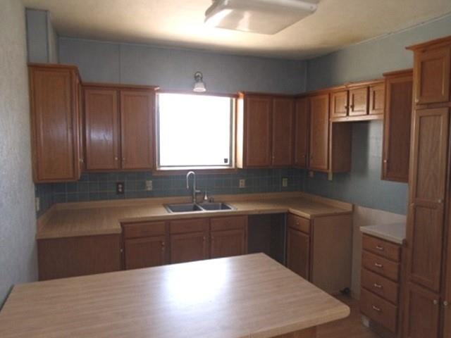 2218 Joliet Street Plainview, TX 79072 - Photo 5 of 9 a kitchen with granite countertop stainless steel appliances a sink stove and refrigerator