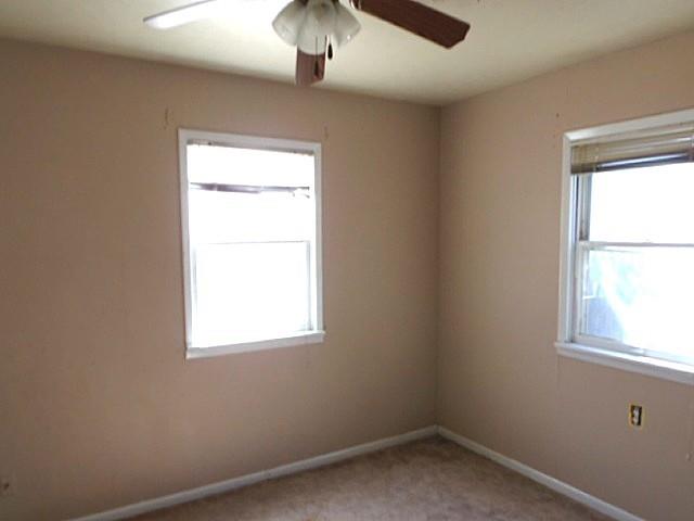 2218 Joliet Street Plainview, TX 79072 - Photo 7 of 9 an empty room with a window and a fan