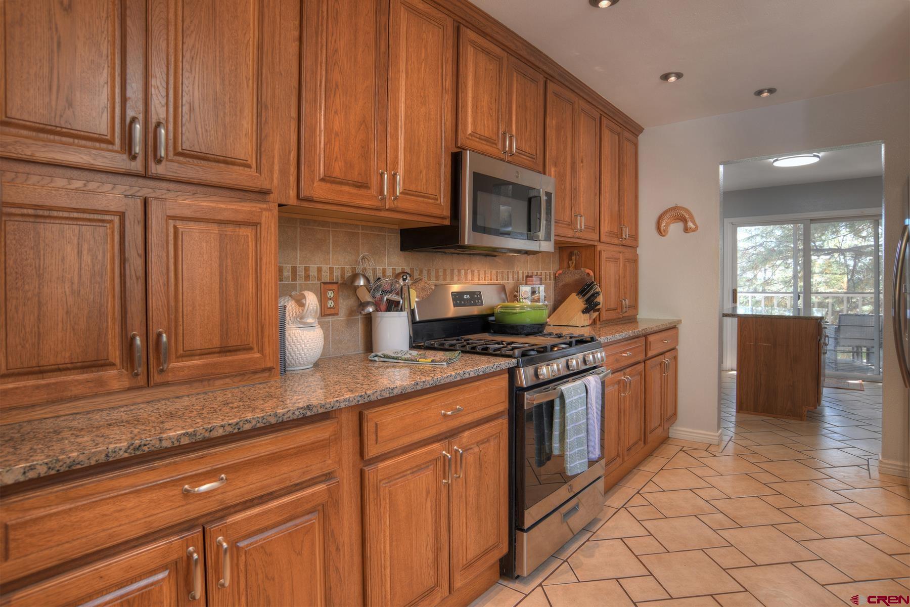 1172 Ridge Road Durango, CO 81303 - Photo 12 of 43 a kitchen with stainless steel appliances granite countertop a stove a sink and a microwave