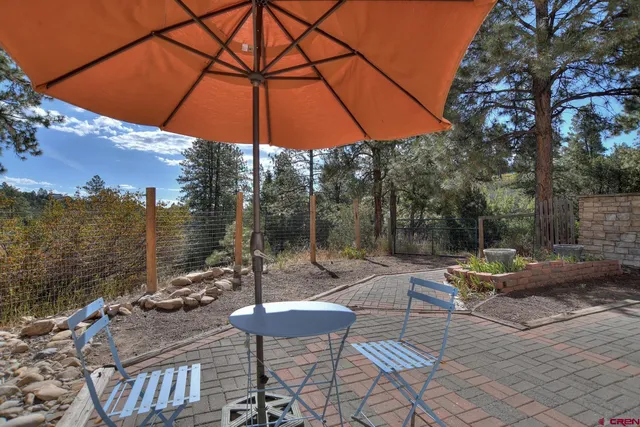 a view of a patio with a table and chairs under an umbrella