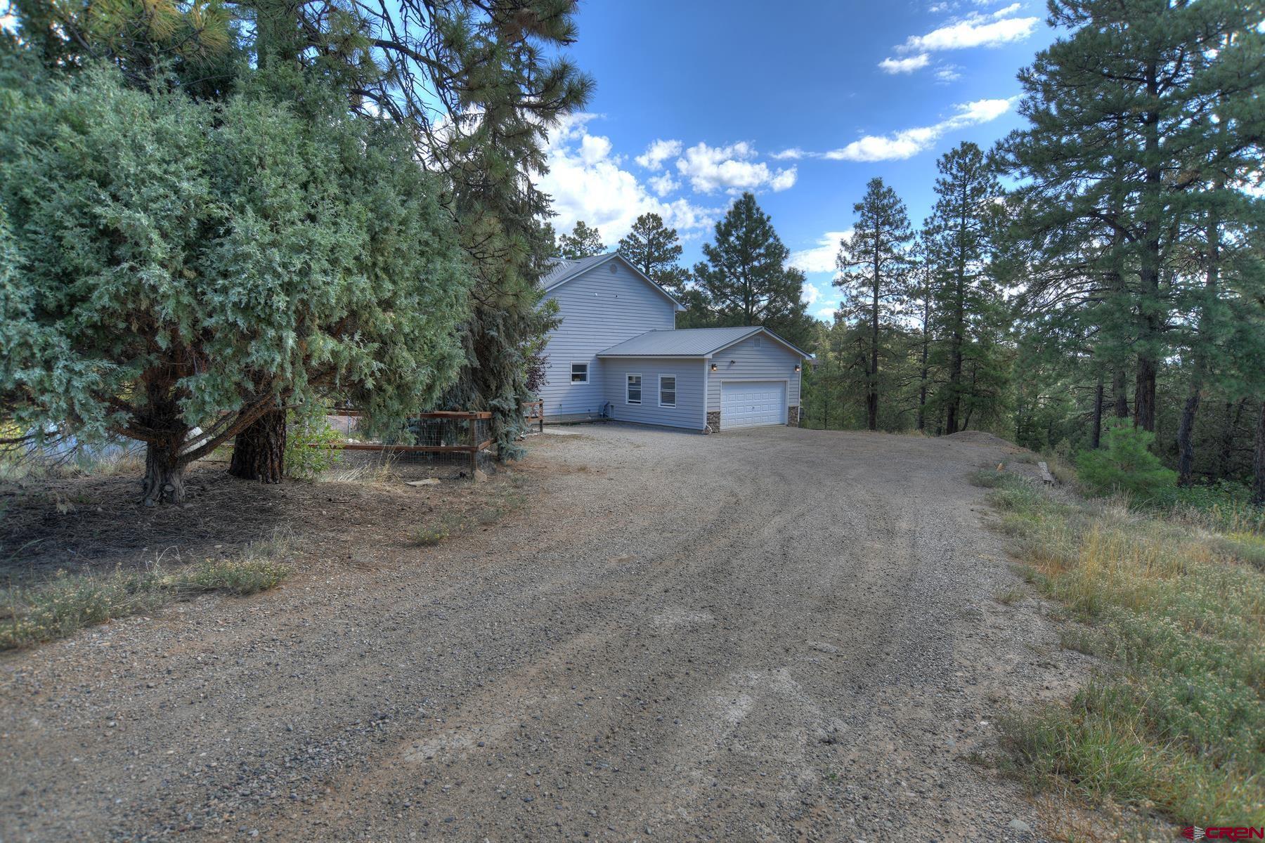 1172 Ridge Road Durango, CO 81303 - Photo 38 of 43 a view of a house with a tree and a yard