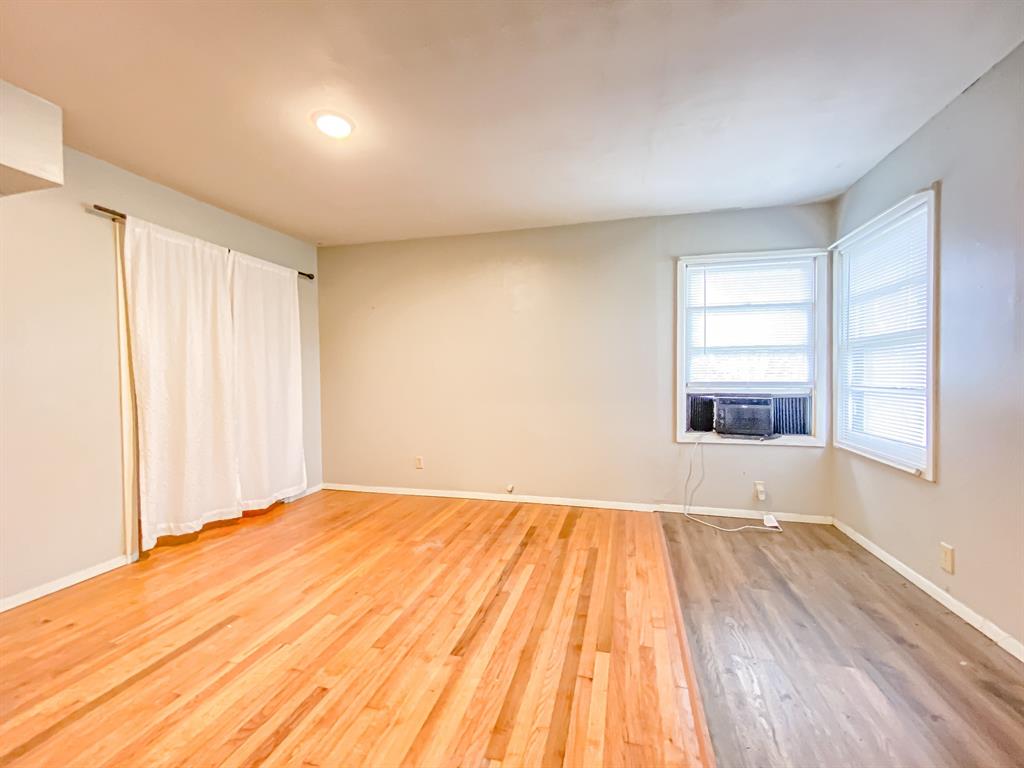 211 Paloma Street Winters, TX 79567 - Photo 14 of 19 a view of an empty room with a window and wooden floor