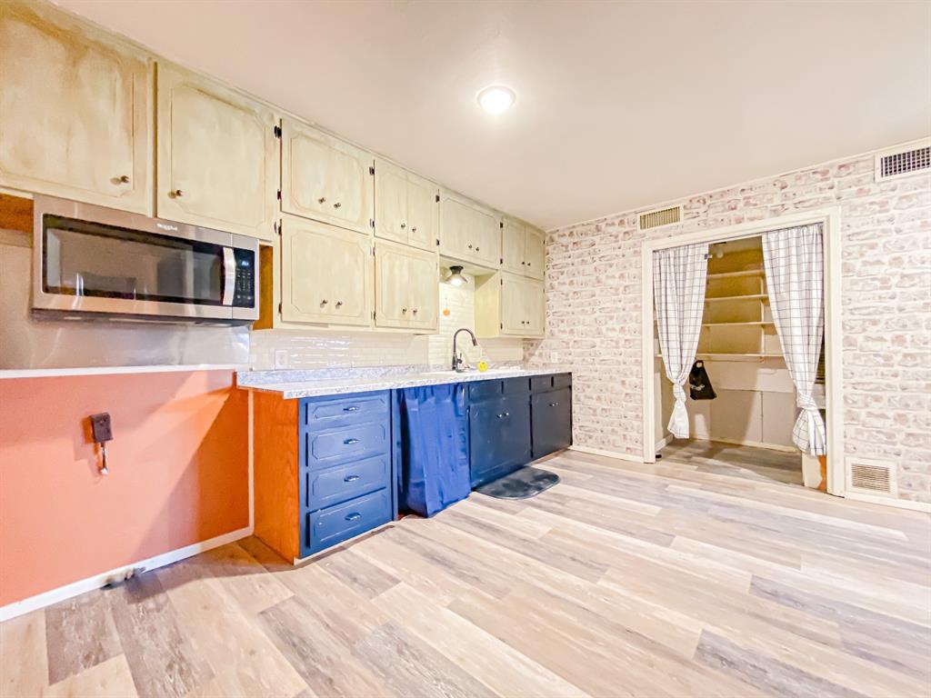 211 Paloma Street Winters, TX 79567 - Photo 4 of 19 a kitchen with stainless steel appliances granite countertop a stove a sink and a microwave
