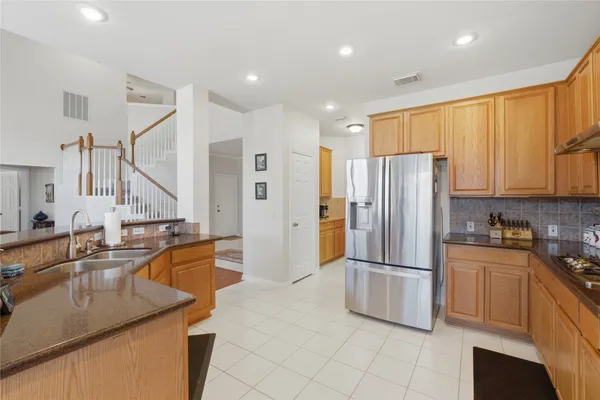 a kitchen with stainless steel appliances granite countertop a refrigerator and a sink