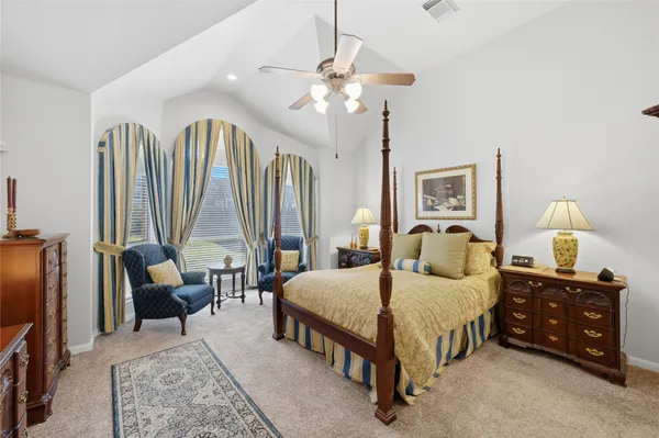 a bedroom with a bed a large window and couch