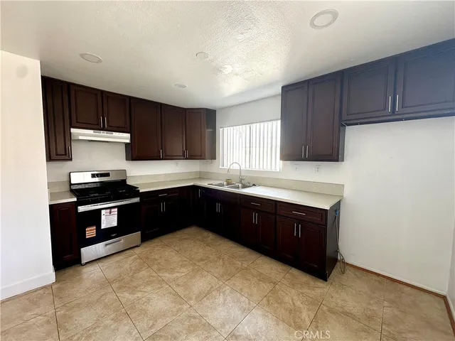 a kitchen with granite countertop wooden cabinets and stainless steel appliances
