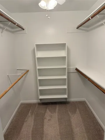 a view of walk in closet with empty racks