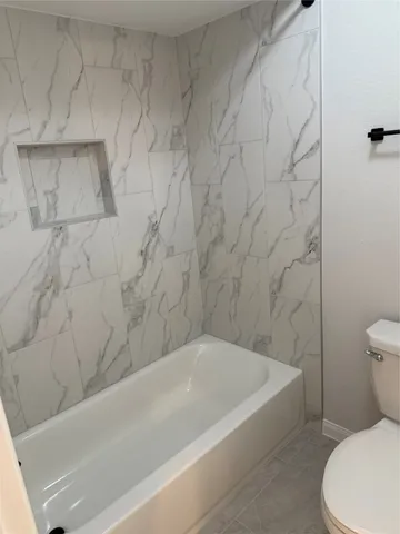 a bathroom with a toilet and a bathtub