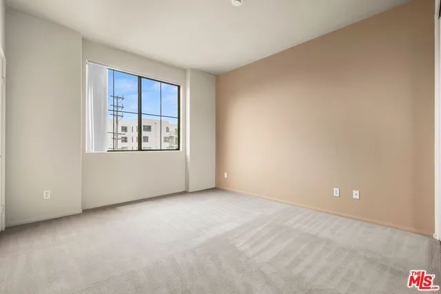 an empty room with windows and closet
