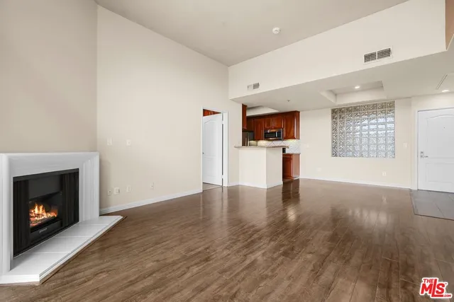 a view of empty room with wooden floor and fireplace