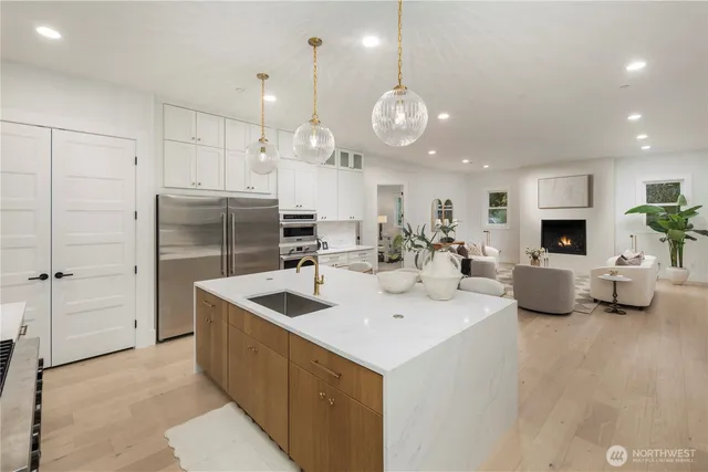 a kitchen with stainless steel appliances granite countertop a sink a stove and a refrigerator