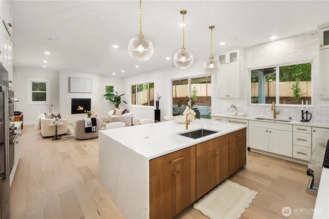 a large kitchen with kitchen island a sink a counter space and living room view