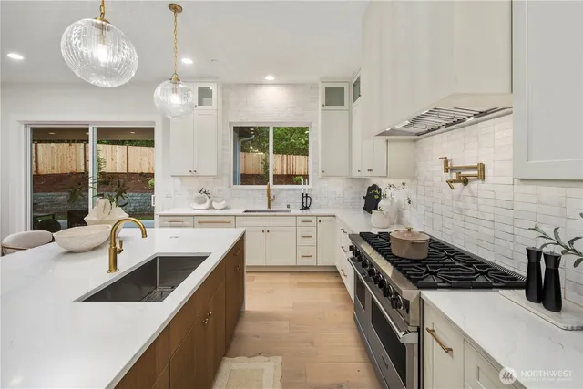 a kitchen with stainless steel appliances a sink stove and cabinets