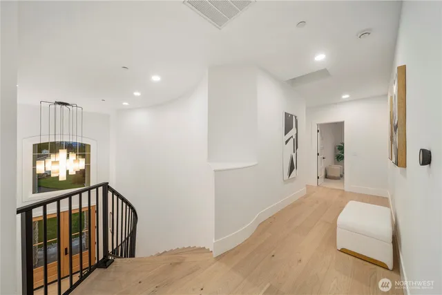 a view of a hallway with a livingroom with furniture and windows