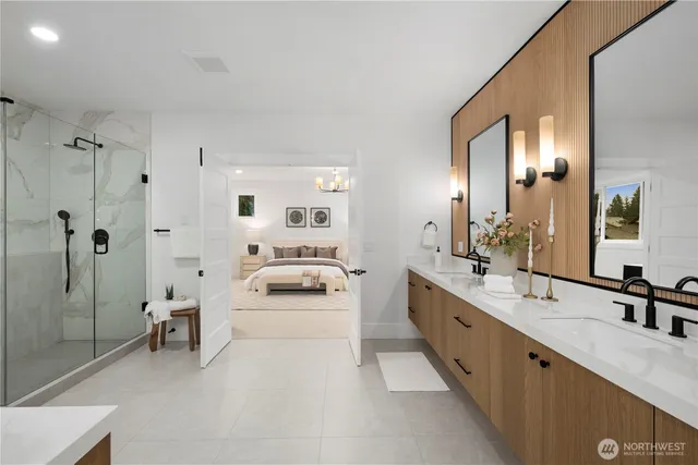 a large white bathroom with a double vanity sink a large mirror and a shower