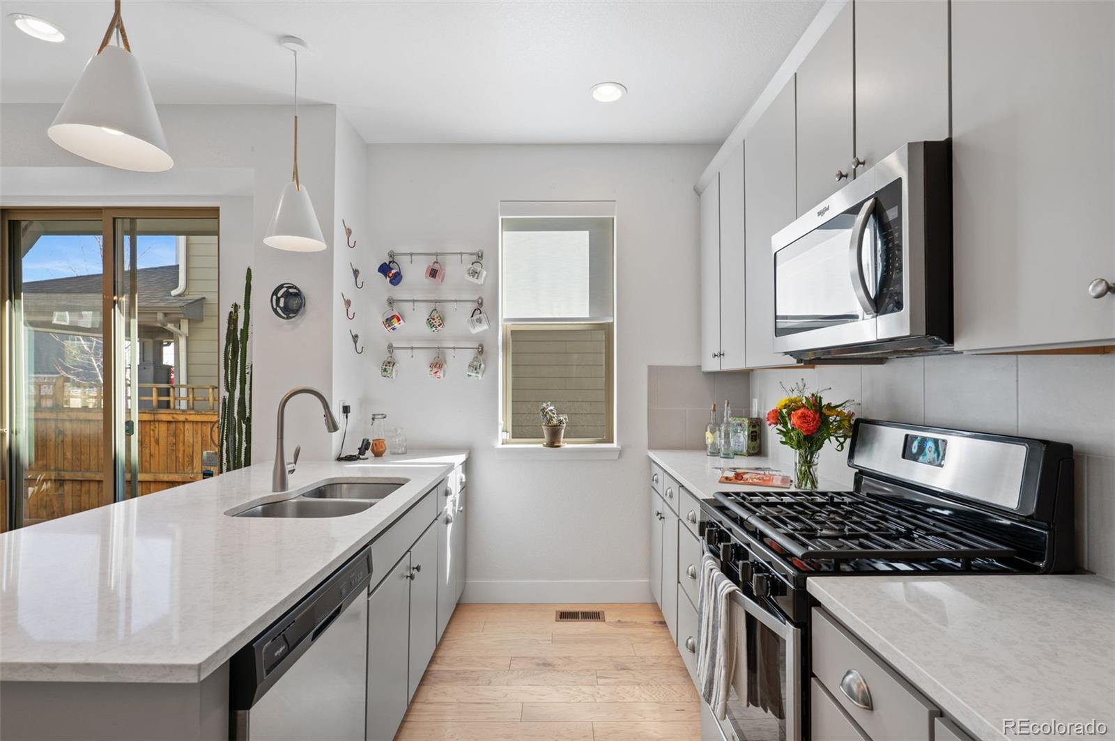 6817 Clay Street Denver, CO 80221 - Photo 11 of 41 a kitchen with stainless steel appliances granite countertop a sink stove and cabinets