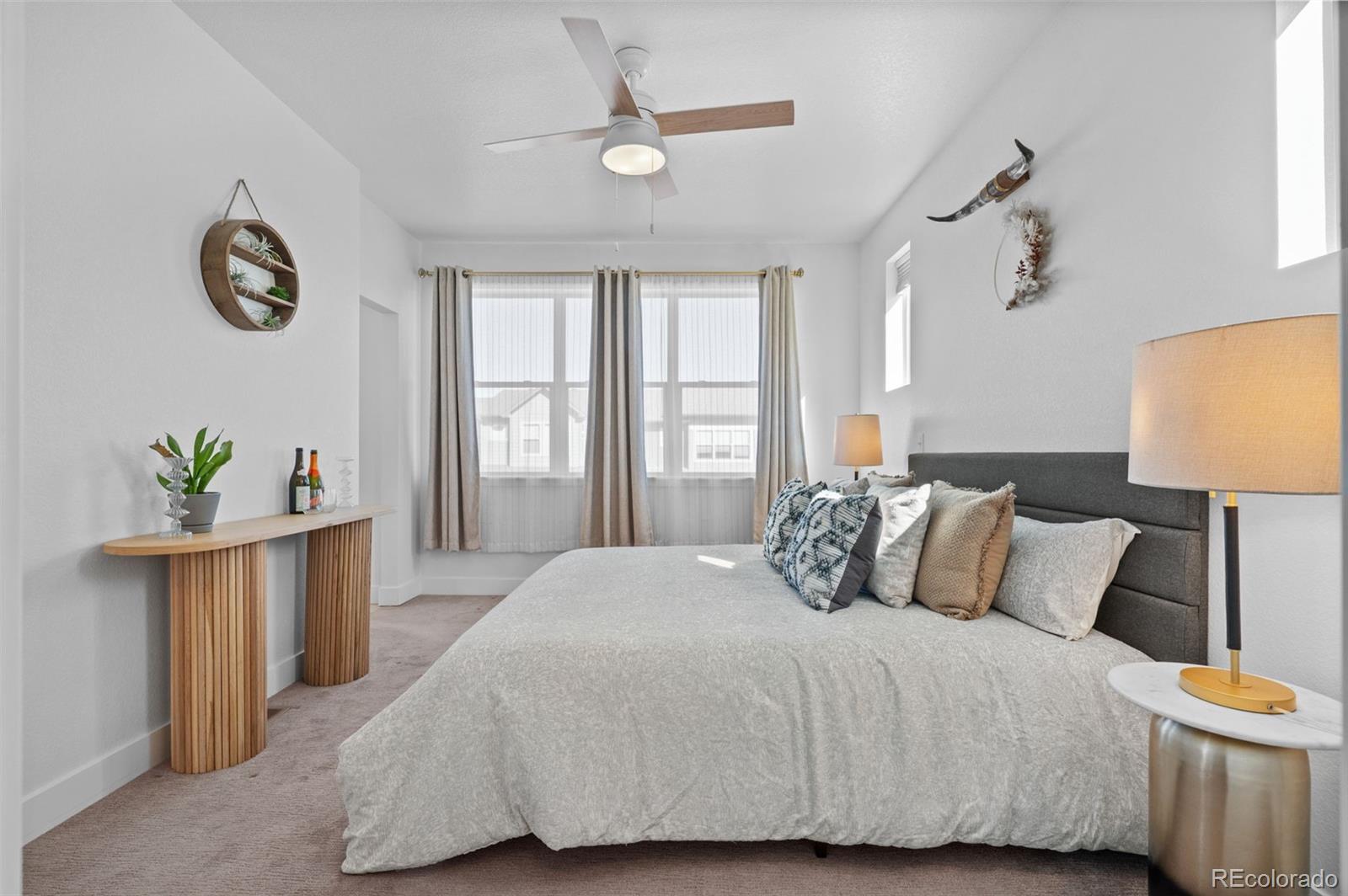 6817 Clay Street Denver, CO 80221 - Photo 16 of 41 a bedroom with a large bed and a chandelier