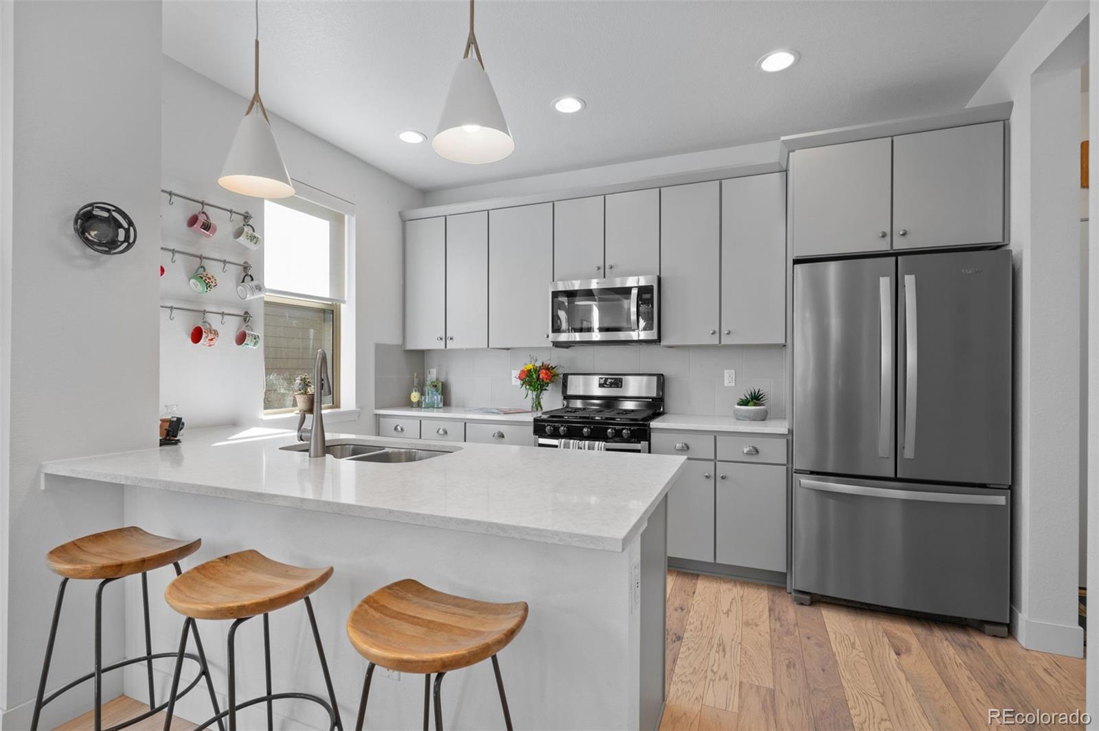 6817 Clay Street Denver, CO 80221 - Photo 10 of 41 a kitchen with stainless steel appliances granite countertop a refrigerator a stove a sink dishwasher and white cabinets with wooden floor