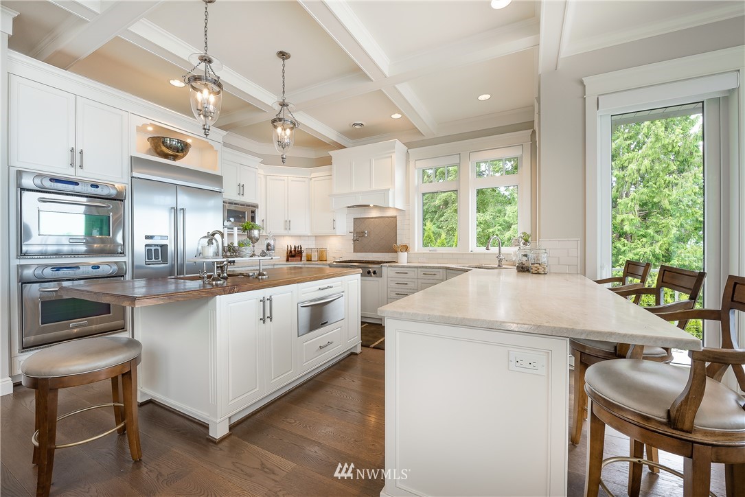 8745 Oertel Drive Blaine, WA 98230 - Photo 10 of 40 a kitchen with a stove a sink a kitchen island with chairs and wooden floor