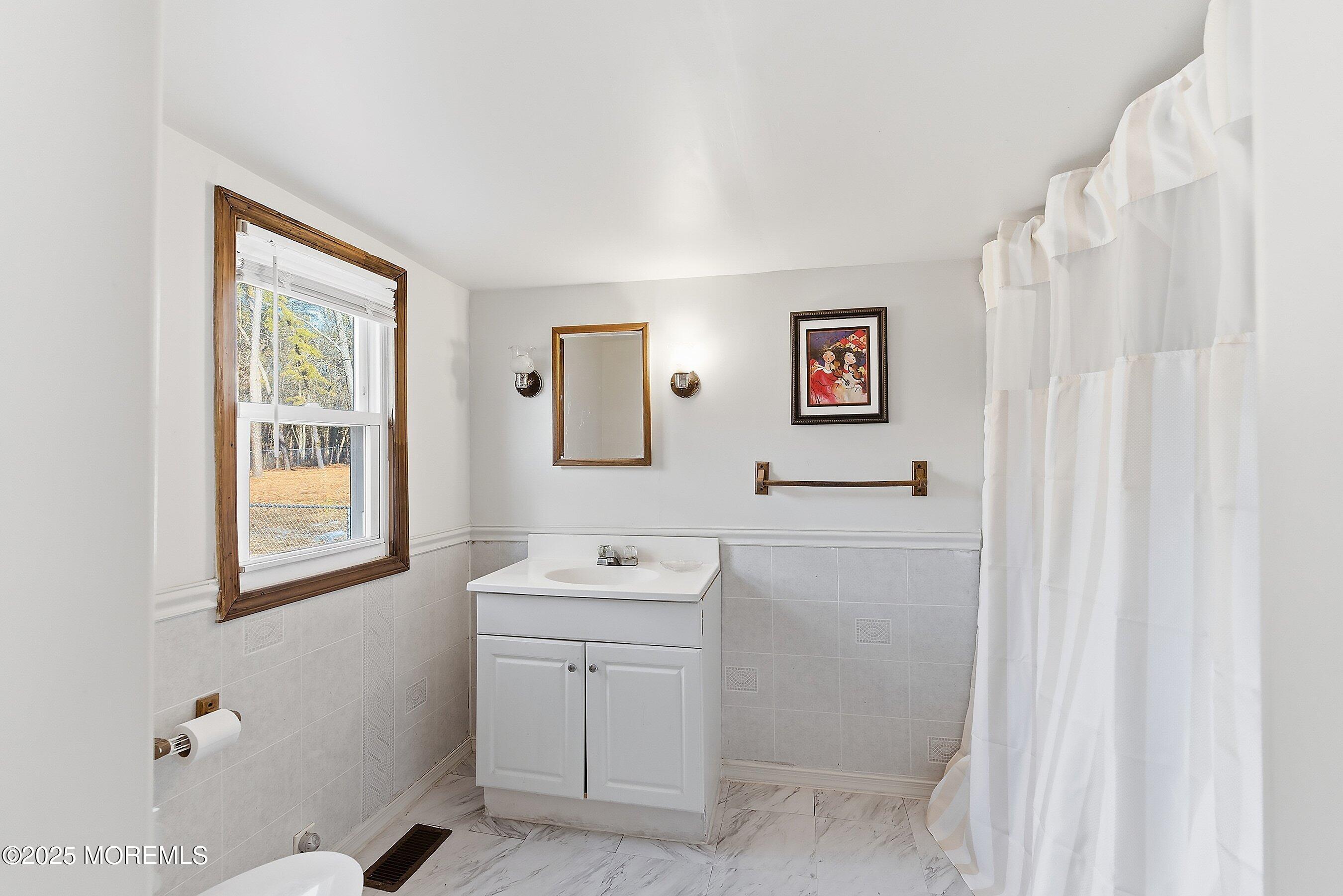 491 Lakehurst Road Browns Mills, NJ 08015 - Photo 11 of 15 a bathroom with a sink a toilet and a window