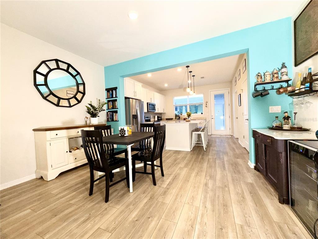 2208 Gopher Tortoise Terrace Oakland, FL 34787 - Photo 7 of 50 a dining room with wooden floor a chandelier a wooden table and chairs