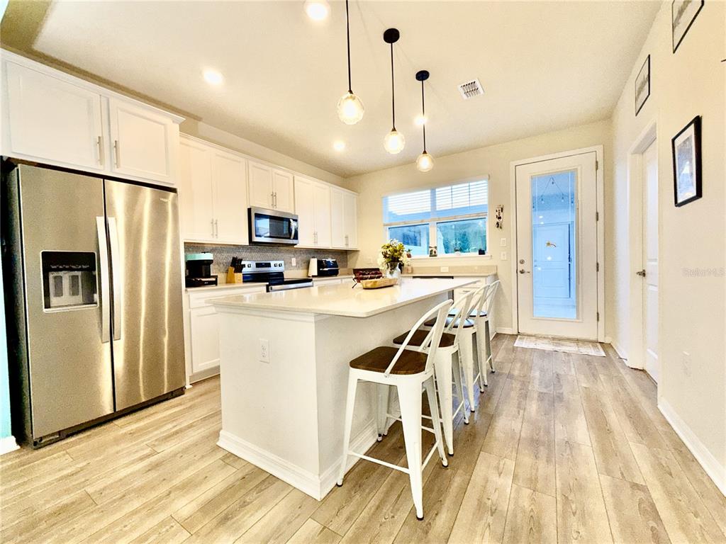 2208 Gopher Tortoise Terrace Oakland, FL 34787 - Photo 8 of 50 a kitchen with stainless steel appliances a refrigerator a stove top oven and a center island