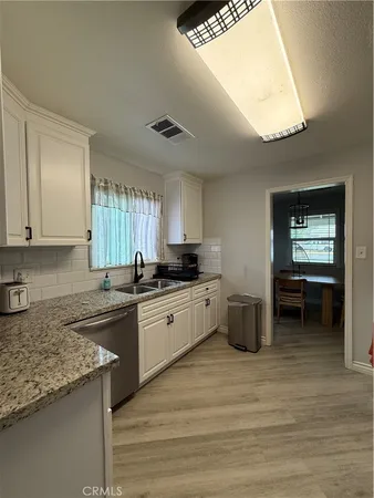 a kitchen with stainless steel appliances granite countertop a sink and cabinets