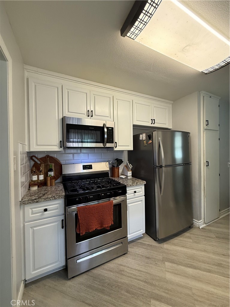 1025 Davids Road Perris, CA 92571 - Photo 5 of 13 a kitchen with stainless steel appliances a stove a microwave and a refrigerator