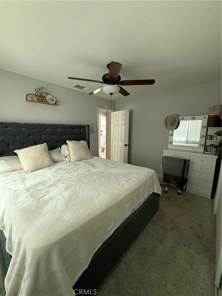 1025 Davids Road Perris, CA 92571 - Photo 8 of 13 a bedroom with a bed and a chandelier