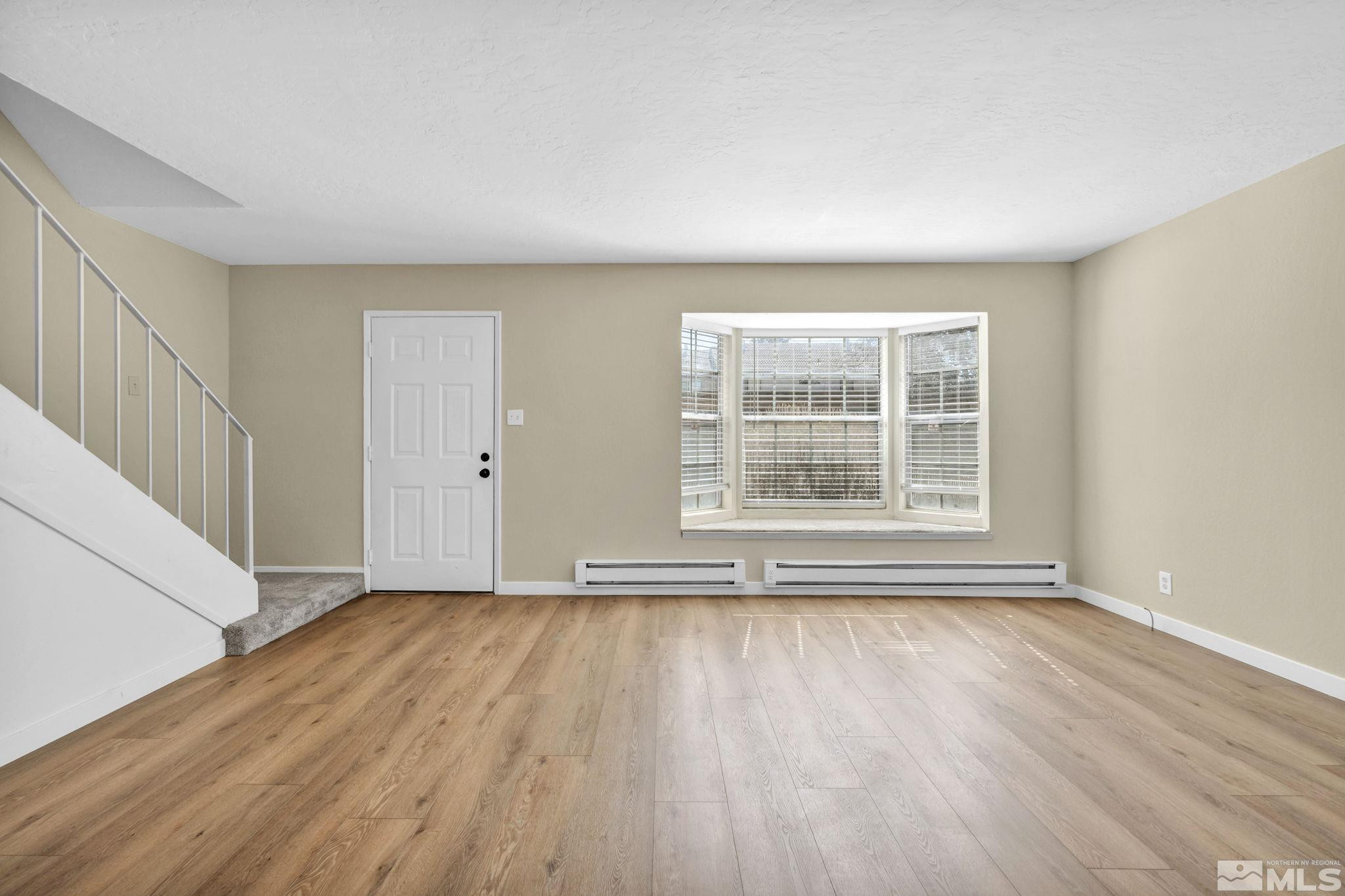 435 Pine Meadows Drive, Unit 33 Sparks, NV 89431 - Photo 7 of 17 a view of an empty room with wooden floor and a window