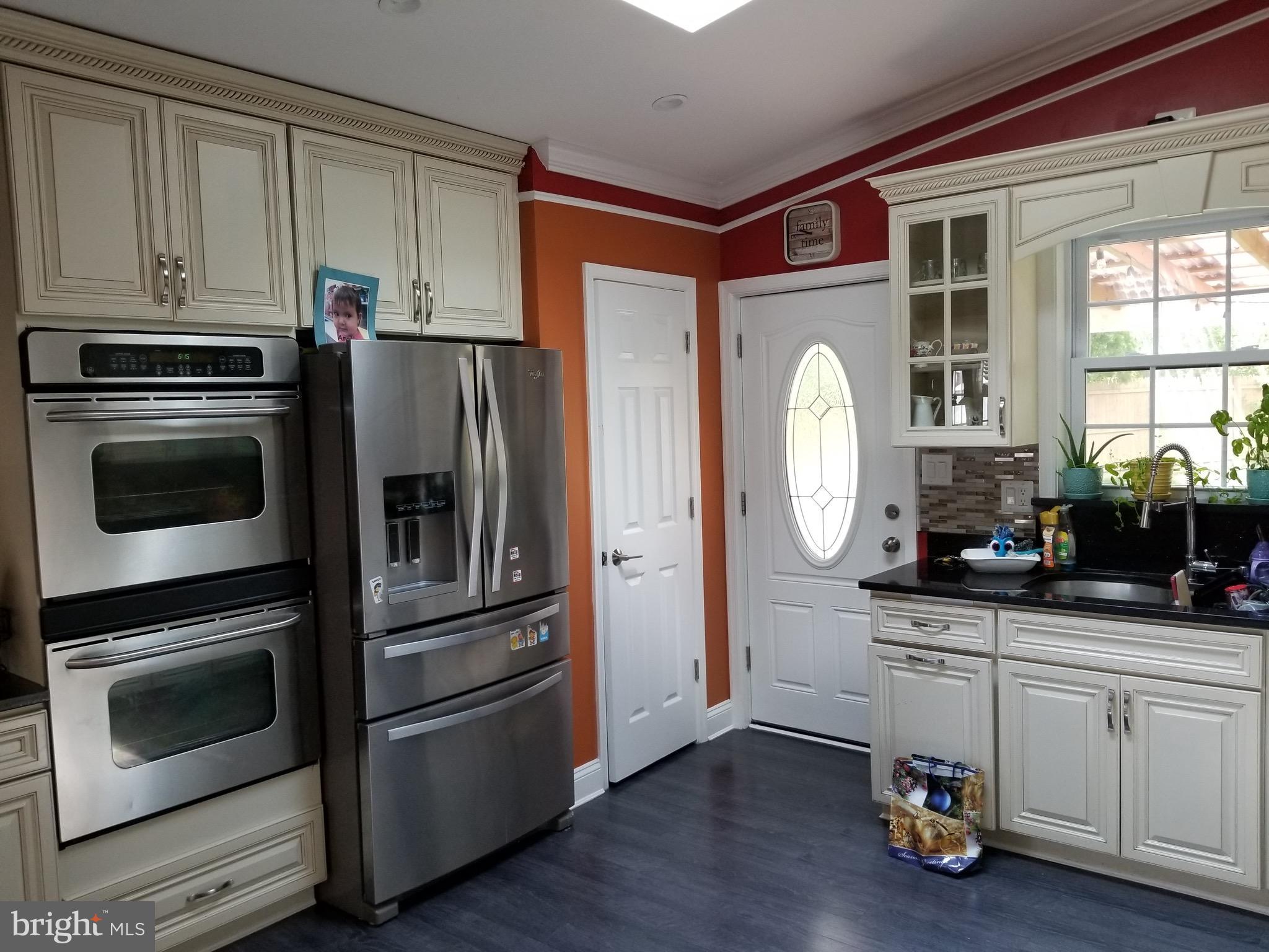 6218 Apache Street Springfield, VA 22150 - Photo 7 of 30 a kitchen with granite countertop a refrigerator and a stove top oven