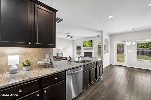 a kitchen with granite countertop stainless steel appliances a sink stove and cabinets