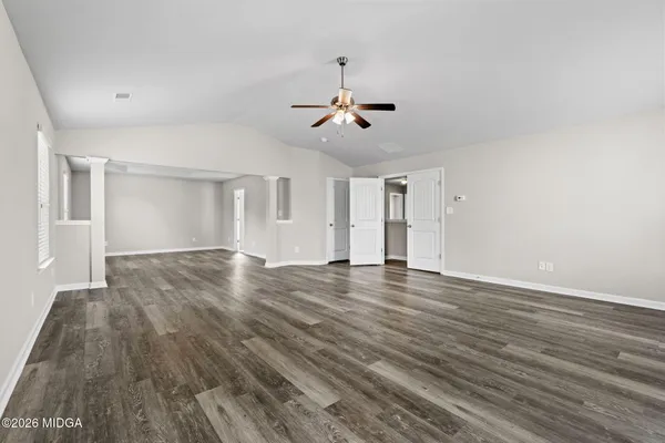 a view of a room with wooden floor and ceiling fan