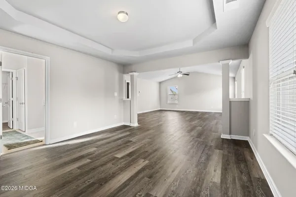 an empty room with wooden floor and windows