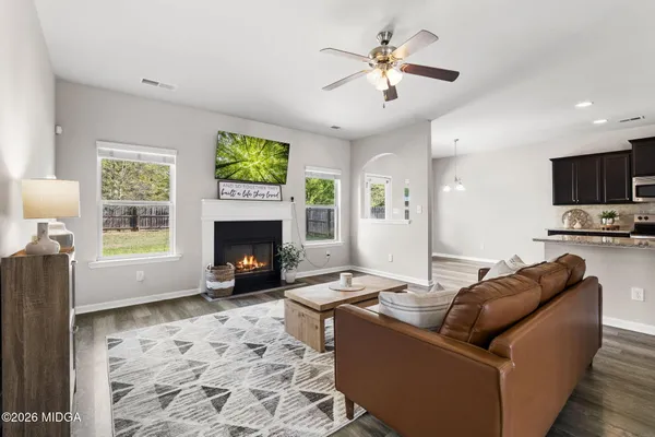 a living room with furniture a fireplace and a flat screen tv