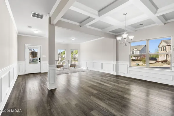 a view of a big room with wooden floor and a kitchen