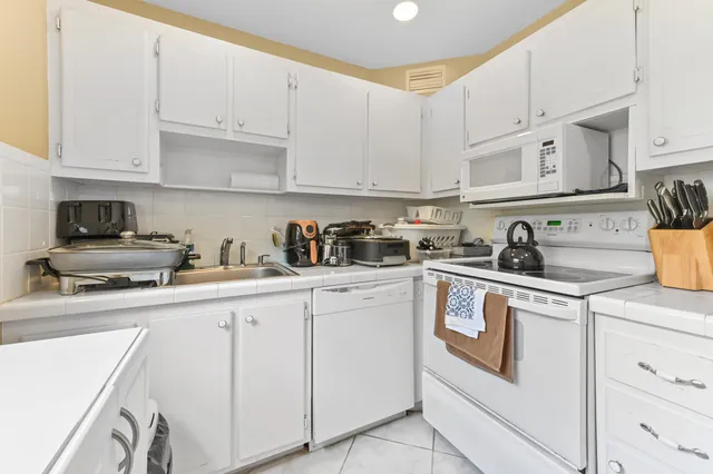 a kitchen with cabinets appliances a sink and a counter top