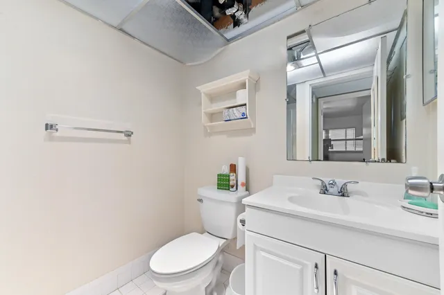 a bathroom with a sink mirror vanity and toilet